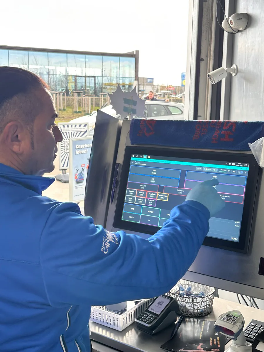 Mitarbeiter bedient das Pay2Clean-Kassenterminal an der Waschstraße